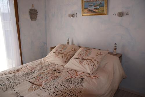 a white bed with pillows on it in a bedroom at Les Coquelicots in Pompéjac