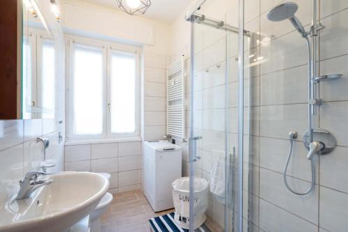 a bathroom with a sink and a glass shower at Casa Martina- Airport free shuttle-H24 in Bergamo