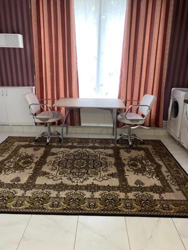 een tafel en stoelen in een kamer met een tapijt bij SorocaMotel in Soroca