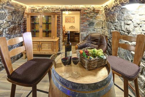 a table with two glasses of wine and a basket of fruit at Pension H.Blatná in Horní Blatná