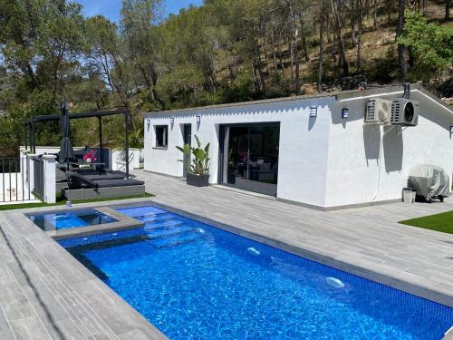 uma pequena casa com piscina ao lado de um edifício em Lux@Spa em Vallirana