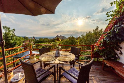 a patio with a table and chairs on a balcony at Szőlőhegy Vendégház Sümeg in Sümeg
