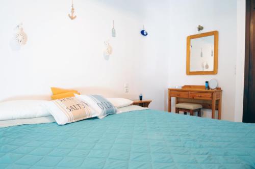 a bedroom with a blue bed with a mirror and a desk at Aris House - Cretan Hospitality in Agios Nikolaos