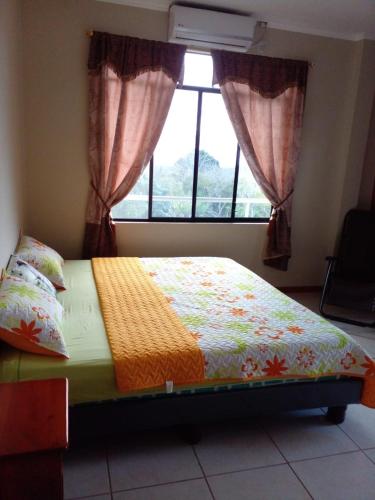 a bed sitting in a bedroom with a window at Cucuve Eco Hostal in Puerto Baquerizo Moreno