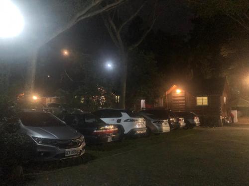 uma fila de carros estacionados num parque de estacionamento à noite em UT Chaung Homestay 