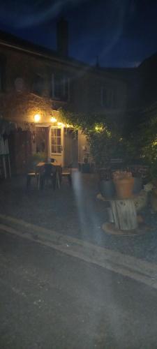 a backyard at night with a table and chairs at Le Relais de Chassepierre in Chassepierre