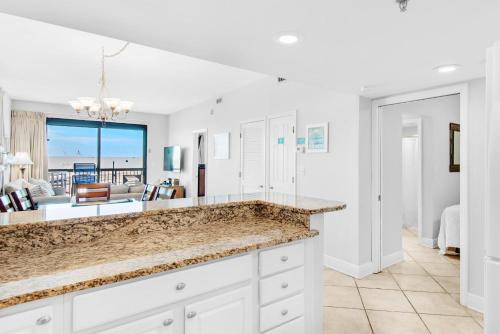 a kitchen with white cabinets and a view of the ocean at SunDestin 101 in Destin