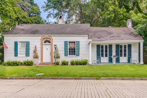 a white house with blue shutters and a yard at Steele Cottage in Vicksburg