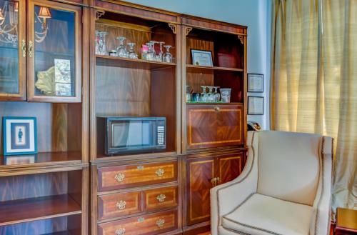 a living room with a tv and a chair at Steele Cottage in Vicksburg