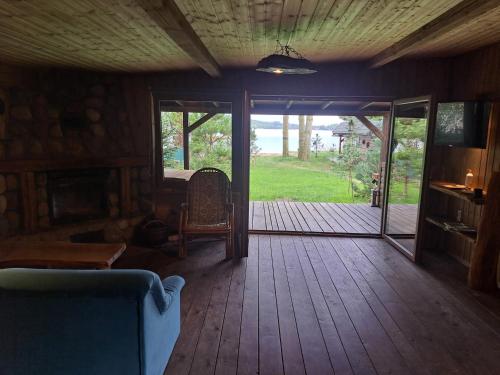 a living room with a wooden floor and a sliding glass door at Siedlisko nad Jeziorem-Mazury in Mrągowo
