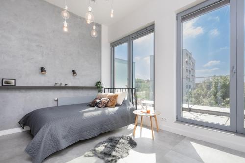 a bedroom with a bed and a large window at Kraków Loft in Krakow