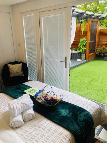 a bed with two towels and a basket on it at MeeZee Pearl Double Bed Lodge With Free Parking in Manchester