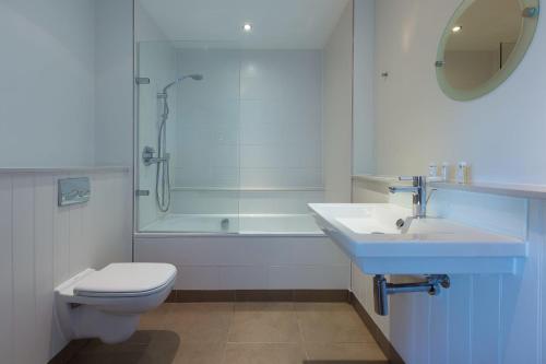 a bathroom with a toilet and a sink and a shower at Coast in St Ives