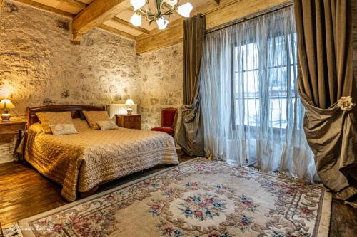 a bedroom with a bed and a large window at Bastide de Tournon d'Agenais in Tournon-dʼAgenais
