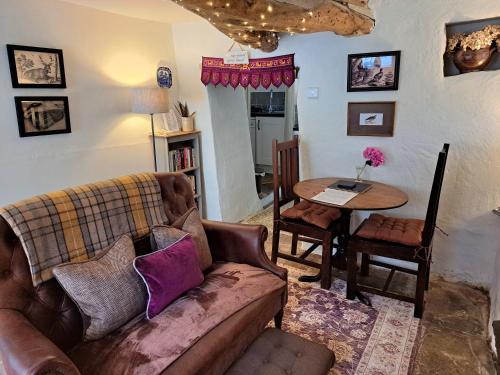 a living room with a couch and a table at Beebole Cottage in Askrigg
