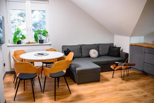 a living room with a couch and a table and chairs at Wójcik SPA - Krynica Zdrój in Krynica Zdrój