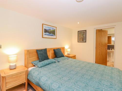 a bedroom with a bed with blue pillows at Ladstock Cottage in Keswick