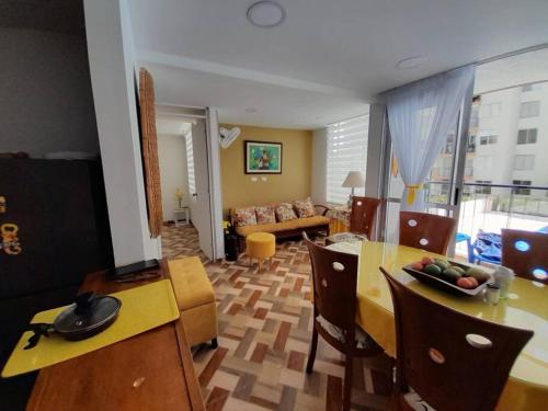 - un salon avec une table, des chaises et un canapé dans l'établissement Apartamento en conjunto hacienda Peñaliza Limonar, à Ricaurte