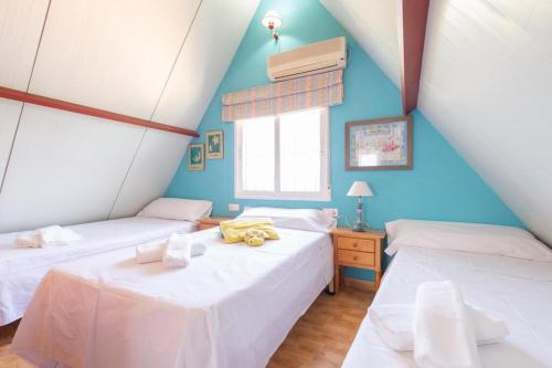 two beds in a room with blue walls at Casita entre naranjas in Formentera de Segura
