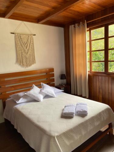 a bedroom with a bed with two towels on it at HAUS KÖHEL HOSPEDAJE POZUZO in Pozuzo