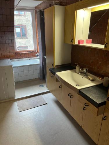 a bathroom with a sink and a window and a tub at Christina in Aalborg