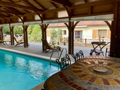 une terrasse avec une piscine, une table et des chaises dans l'établissement St Amour - Maison en Dordogne avec piscine, à Terrasson