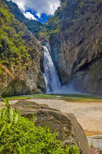 a waterfall in the middle of a mountain at Peace By The River in Jarabacoa