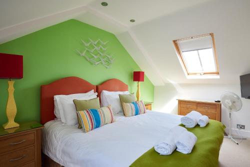 a bedroom with a large bed with towels on it at 252 Aldeburgh Townhouse - Aldeburgh Coastal Cottages in Aldeburgh