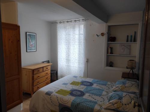 a bedroom with a bed and a dresser and a window at Maison de village dans une rue calme in Ax-les-Thermes