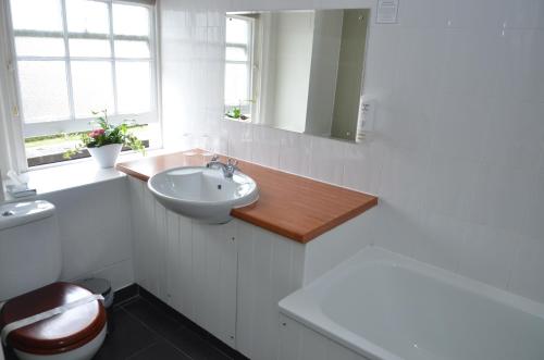 a white bathroom with a sink and a toilet at The Broadway Hotel in Letchworth