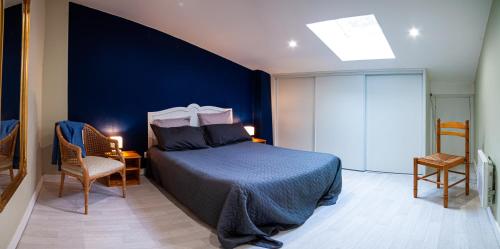 a bedroom with a bed and a blue wall at Maison de campagne in Rions