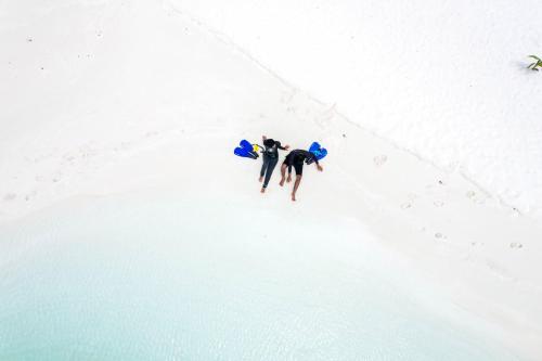 two people are standing in the snow at La Cabana, Maamigili in Maamigili