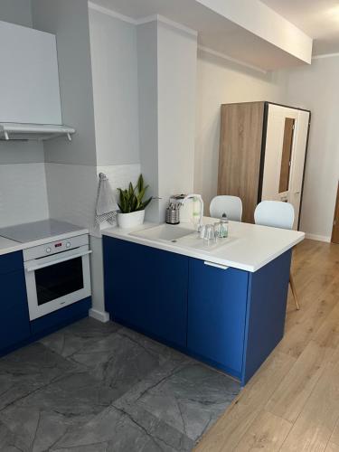 uma cozinha com armários azuis e um balcão branco em Marcinkowskiego 11 - 2 em Katowice