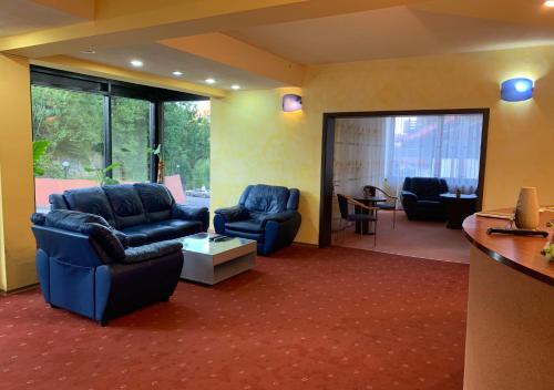a living room with two blue chairs and a table at Vila Condor in Poiana Brasov