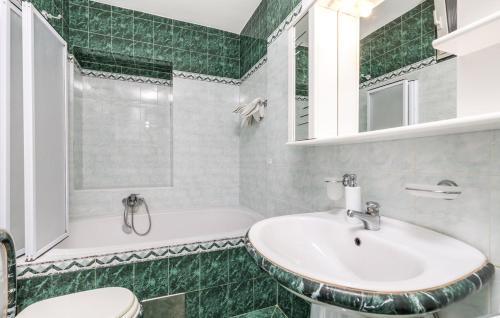 La salle de bains est pourvue d'un lavabo, d'une baignoire et de toilettes. dans l'établissement Vallelosca Garden, à Opatija