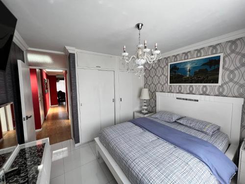 1 dormitorio con cama y lámpara de araña en Departamento por Temporadas, en La Paz