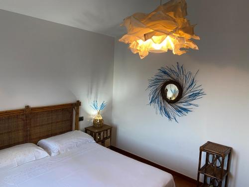 維拉普特祖的住宿－La Rosa dei Venti，一间卧室配有一张床和一个吊灯