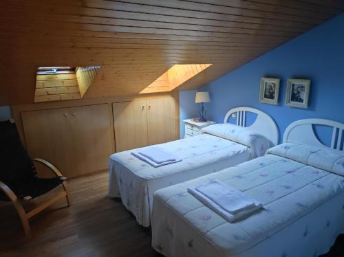 a room with three beds and a wooden ceiling at Fuenteazul in Hortigüela