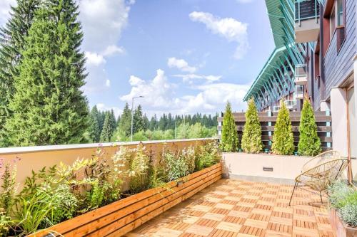 un balcone di un edificio con piante e alberi di Splendor 3 bedroom flat in Silver Mountain a Poiana Brasov