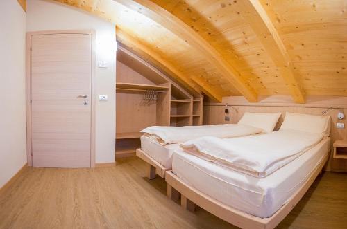 Chalet Alaska في ليفينو: سريرين في غرفة ذات سقف خشبي
