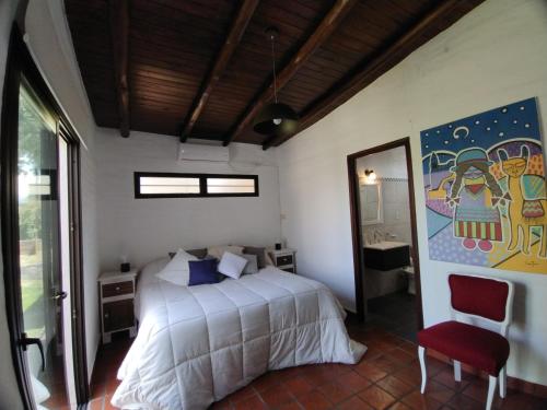 a bedroom with a bed and a painting on the wall at CampoMora- 5 min del Centro - CONFORT - Parrilla & Pileta in San Salvador de Jujuy