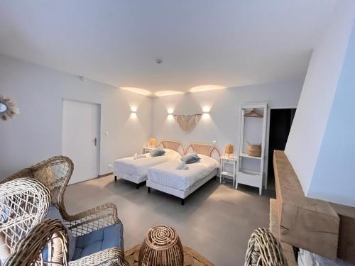 a bedroom with two beds and a living room at Le Clos Joli in Haybes