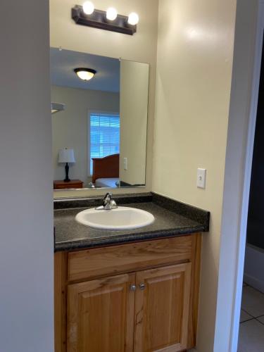 a bathroom with a sink and a mirror at Cottages Christian Retreat in Panama City Beach