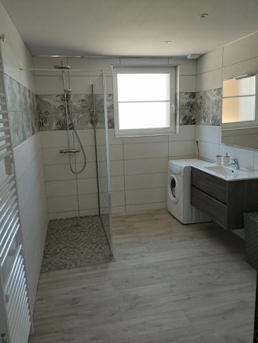 une salle de bain avec douche et lavabo et une machine à laver dans l'établissement Domaine de la Dune Gite entre Terre et Mer, à Saint-Martin-de-Varreville