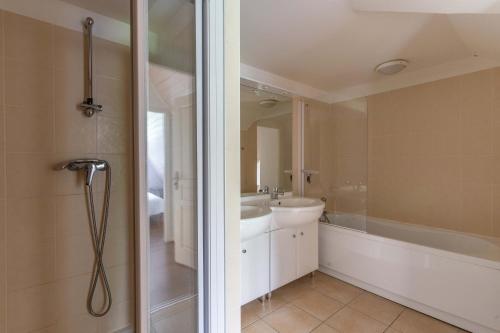 een badkamer met een bad, een wastafel en een douche bij Superbe appartement en hyper centre, proche plage in Arcachon