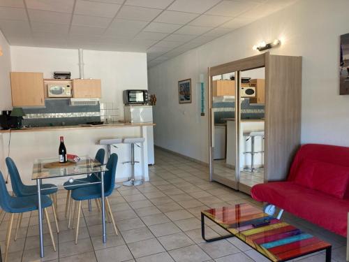 een woonkamer met een rode bank en een tafel bij LES PIEDS DAND L'EAU in Banyuls-sur-Mer