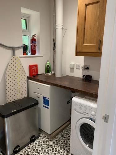 a small kitchen with a washing machine and a counter at Vale View Scalford in Scalford