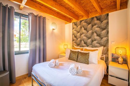 a bedroom with a bed with slippers on it at Le Hameau de Barbette in Coulounieix-Chamiers