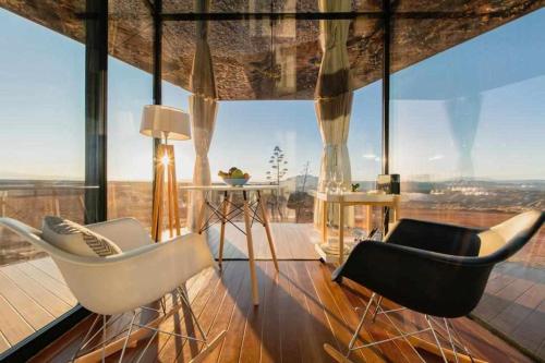 Zimmer mit 2 Stühlen und einem großen Fenster in der Unterkunft La Casa del Desierto in Gorafe