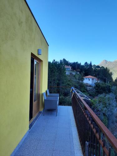 a balcony of a house with a chair on it at Casa dos Moroucinhos in Rio Caldo